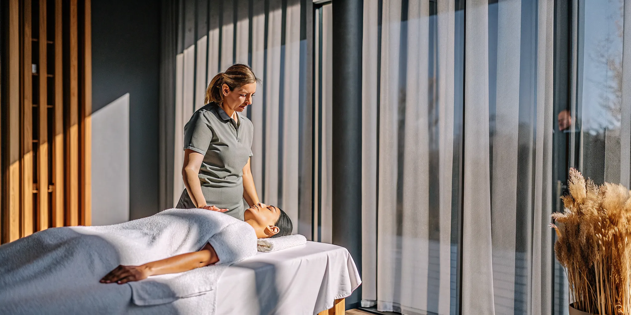A woman receives professional massage therapy from a licensed therapist in a tranquil spa.
