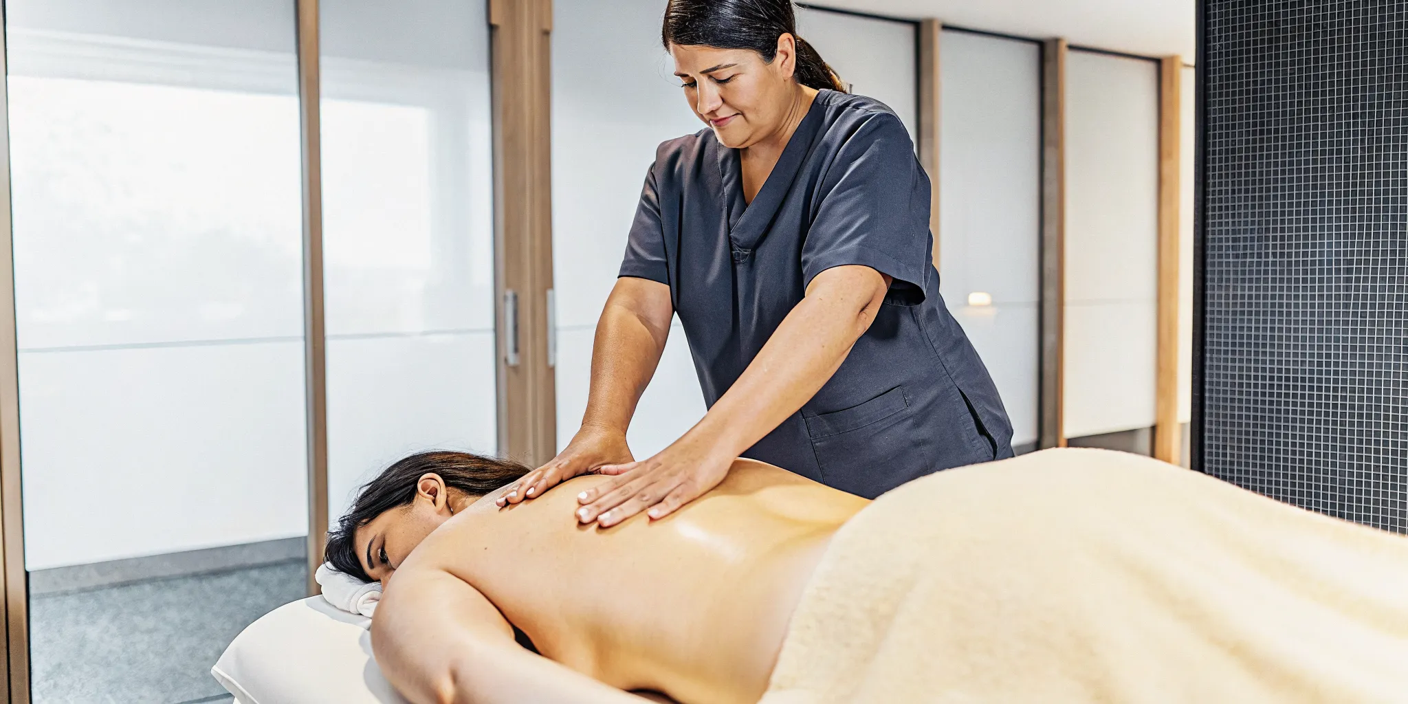Medical massage therapist applying pressure to a patient's back for pain relief.