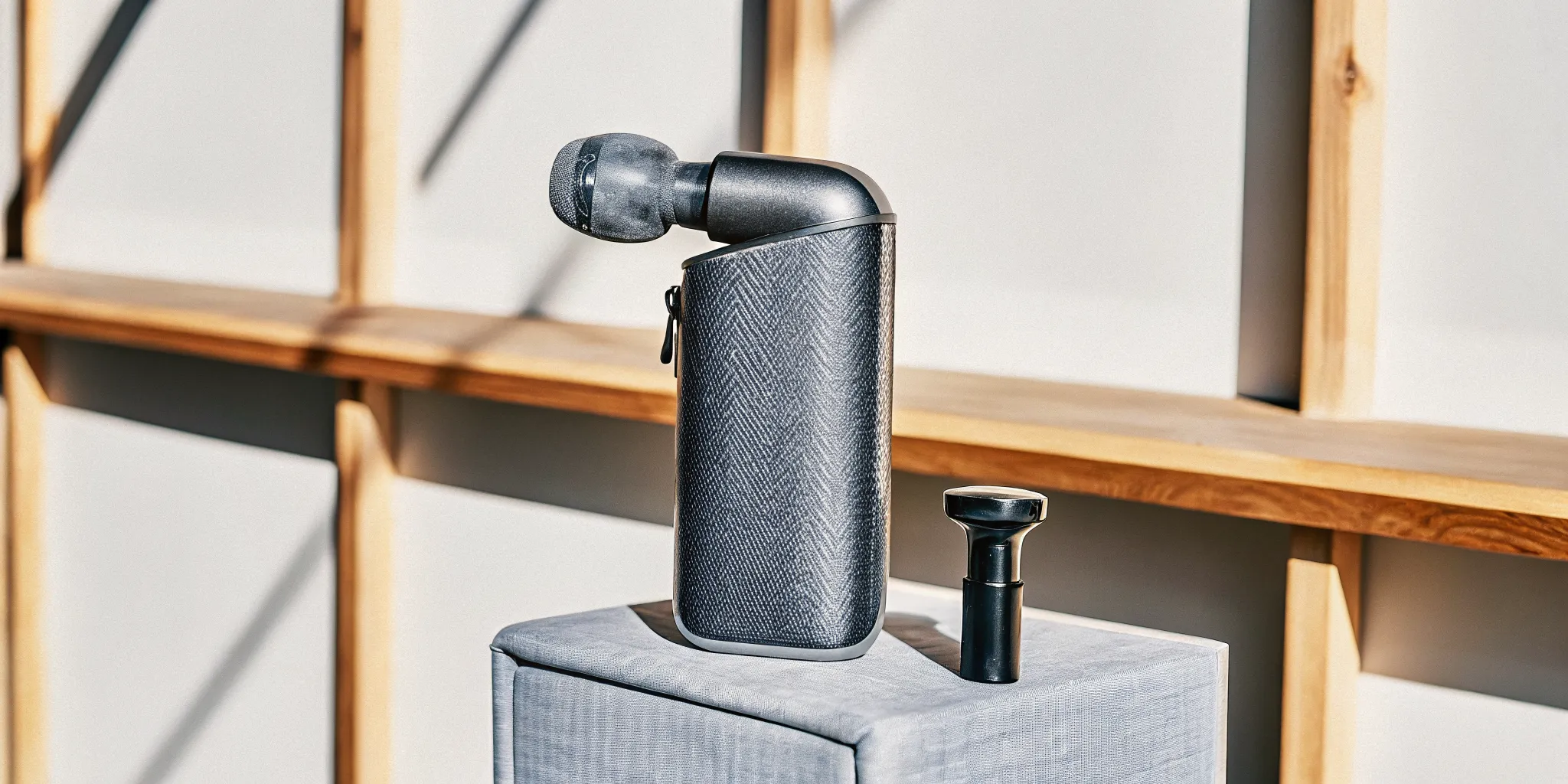A Costco massage gun and its attachments laid out for a buyer's guide review.
