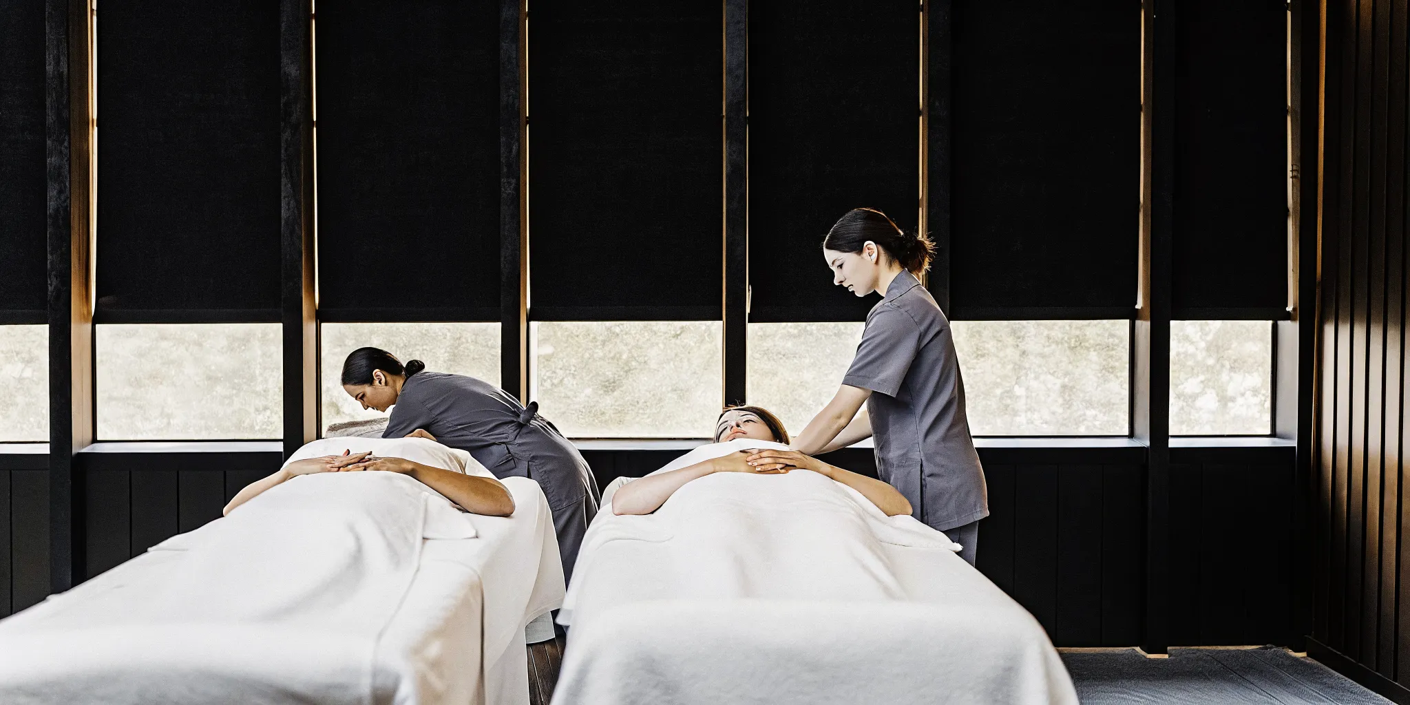Massage therapists, trained in therapy programs, giving professional massages to clients.