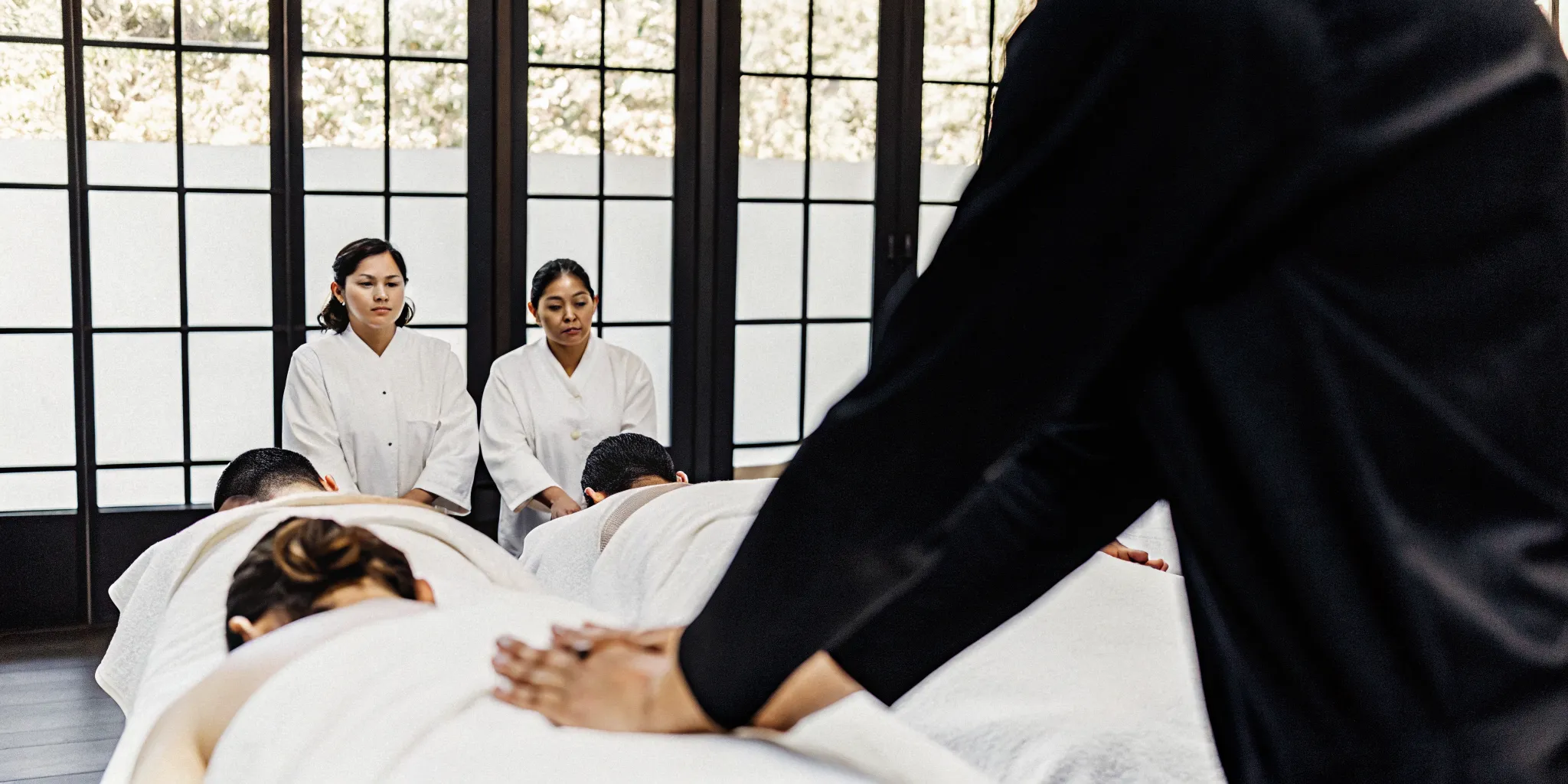 Hands-on massage continuing education course with therapists practicing techniques.