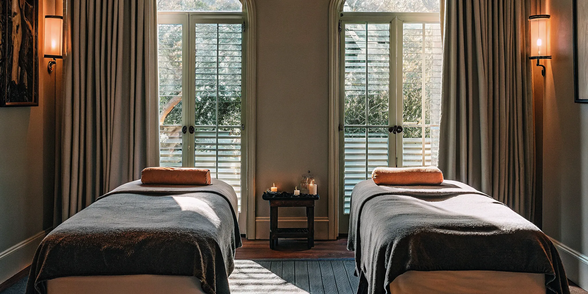 A serene couples massage room with two massage tables side by side in warm natural light
