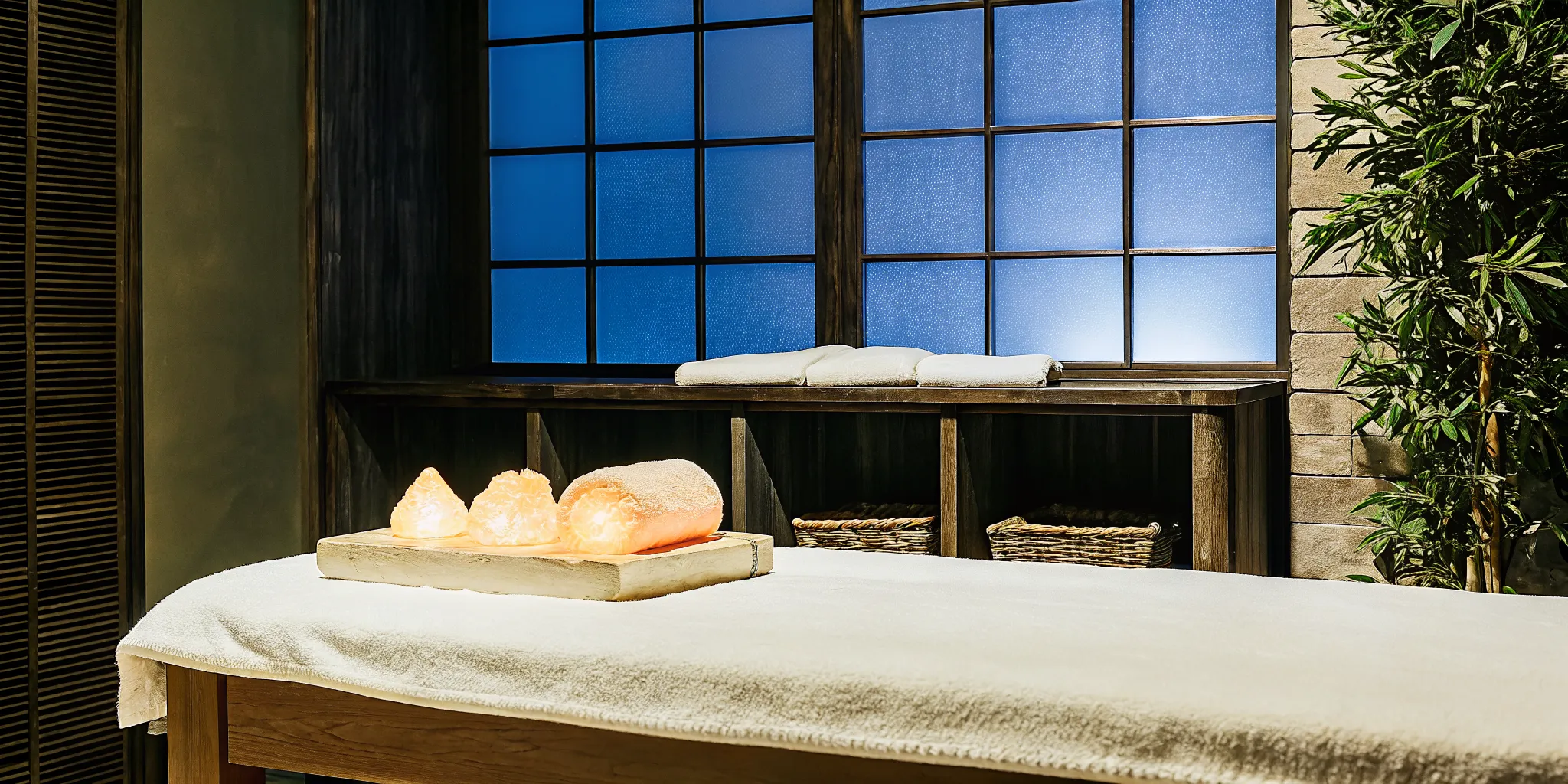Warm glowing Himalayan pink salt stones arranged on a massage table in a serene spa room